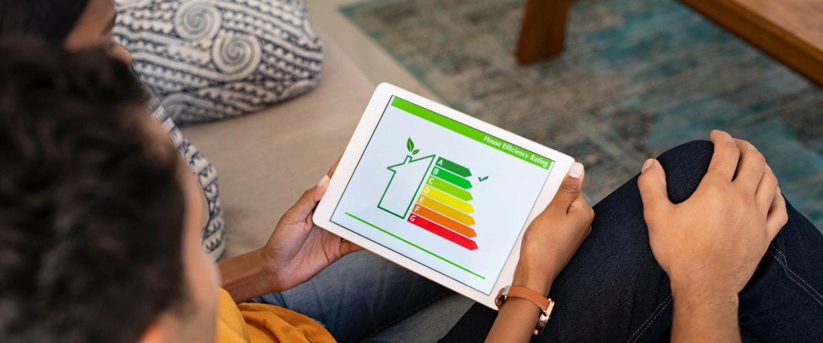 Personen betrachten auf einem Tablet die Energieeffizienzklasse eines Hauses, um Maßnahmen wie Fassadendämmung oder energetische Sanierung zu planen.
